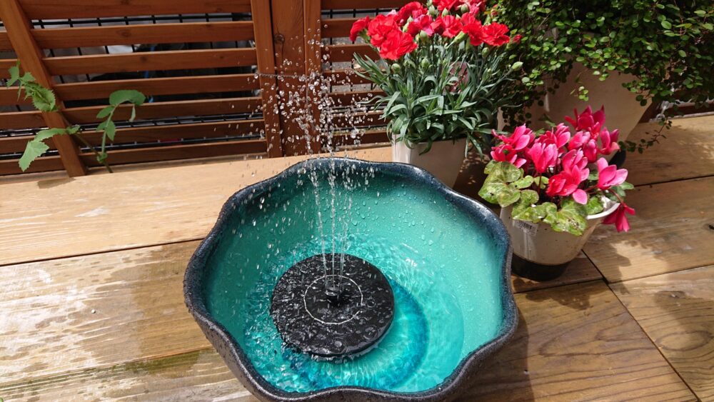 上から見たソーラー噴水と鉢植えの花