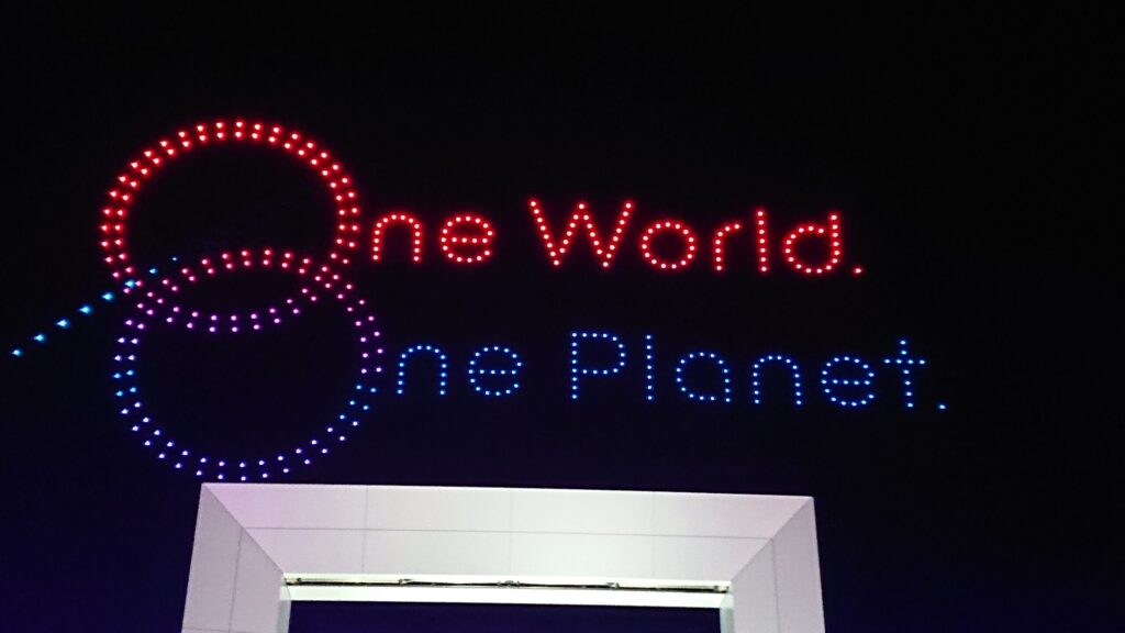 万博ドローンショーにて大会フレーズOneWorldOnePlanetを表す飛行