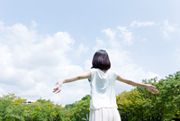 空に向かって背伸びする女性