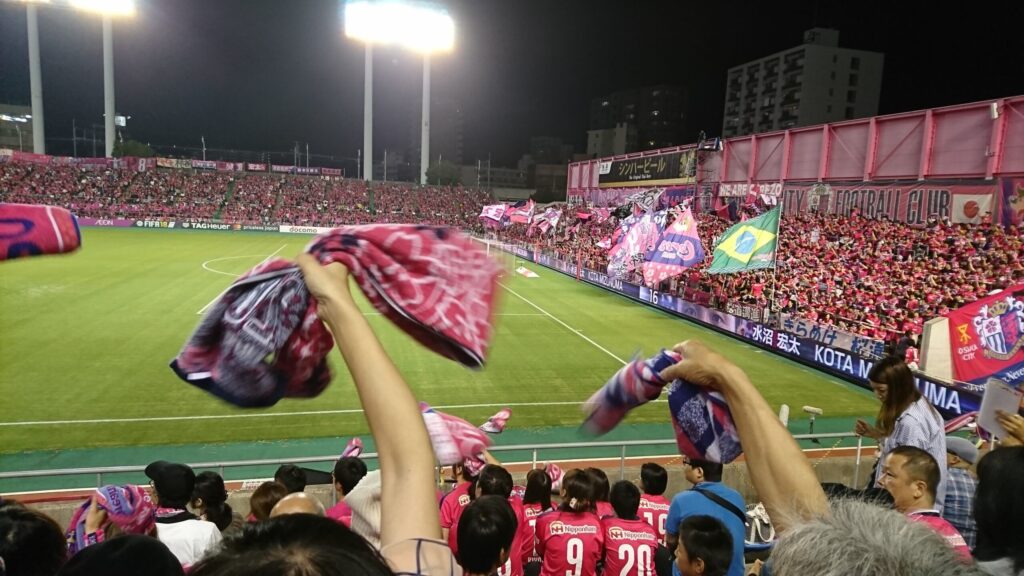 生観戦中のJリーグのスタジアムにてタオルを振り応援する観客