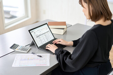 ノートＰＣに向かって事務作業する女性