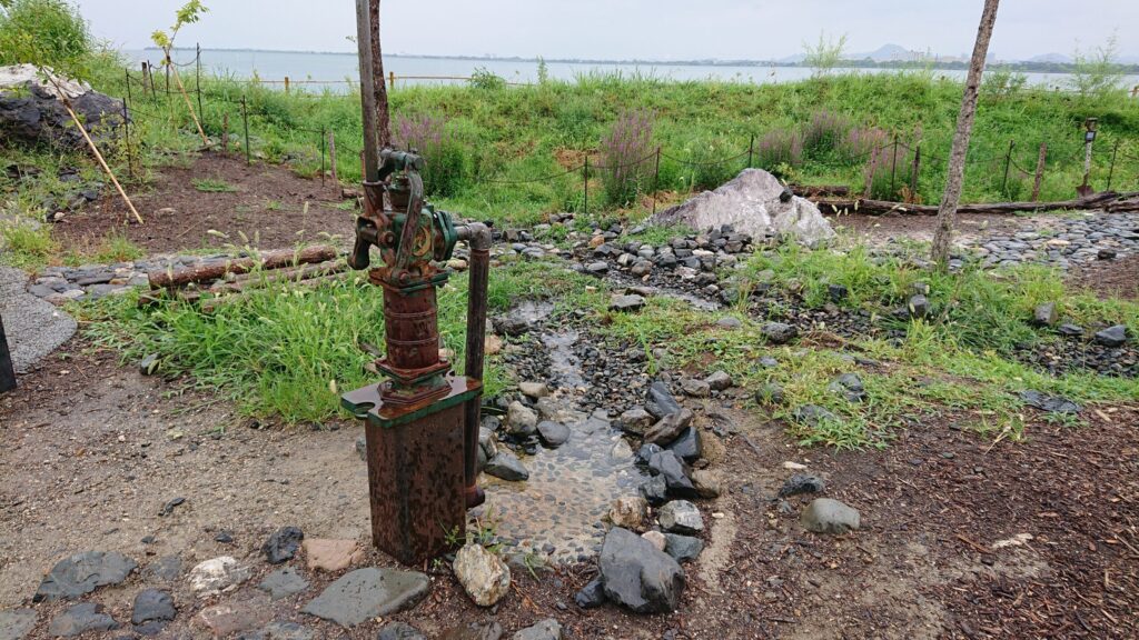 庭園内、手押しポンプと水が流れる様子
