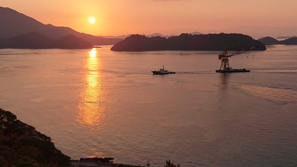 日が昇る中、近づく船