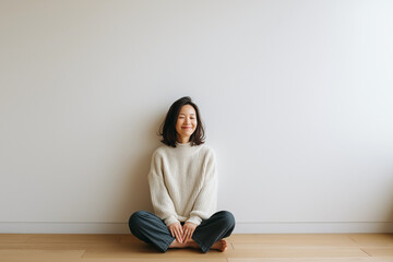 安らぎを感じているかのような女性が座る白い壁の部屋